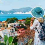 tourist-female-with-blue-sun-hat-and-travel-backpack-enjoying-greek-vivid-colored-assos-town-768x512