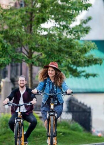 young-tourist-couple-travellers-with-electric-scooters-in-small-town-768x503