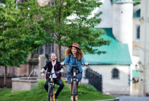 young-tourist-couple-travellers-with-electric-scooters-in-small-town-768x503